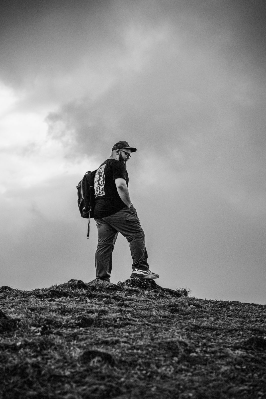 Fotografía en blanco y negro de un hombre en la cima de un cerro