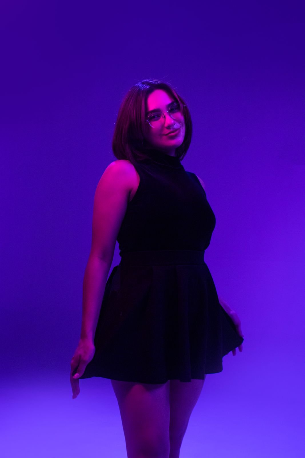 Retrato de estudio de una mujer con vestido negro y luz morada